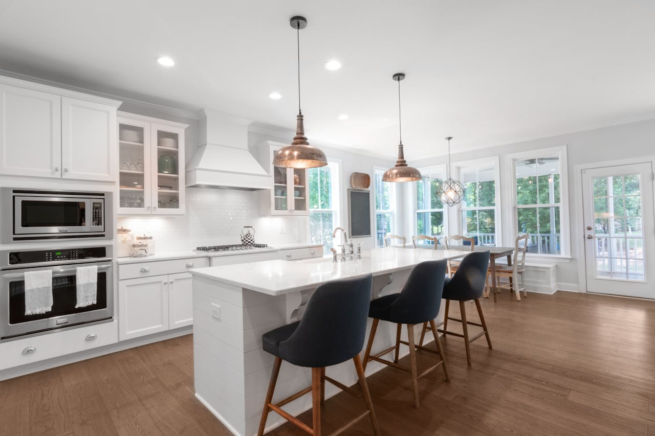 Crafting Captivating Headlines: Your awesome post title goes here Bright and elegant modern kitchen with white cabinets, dining area, and island bar.
